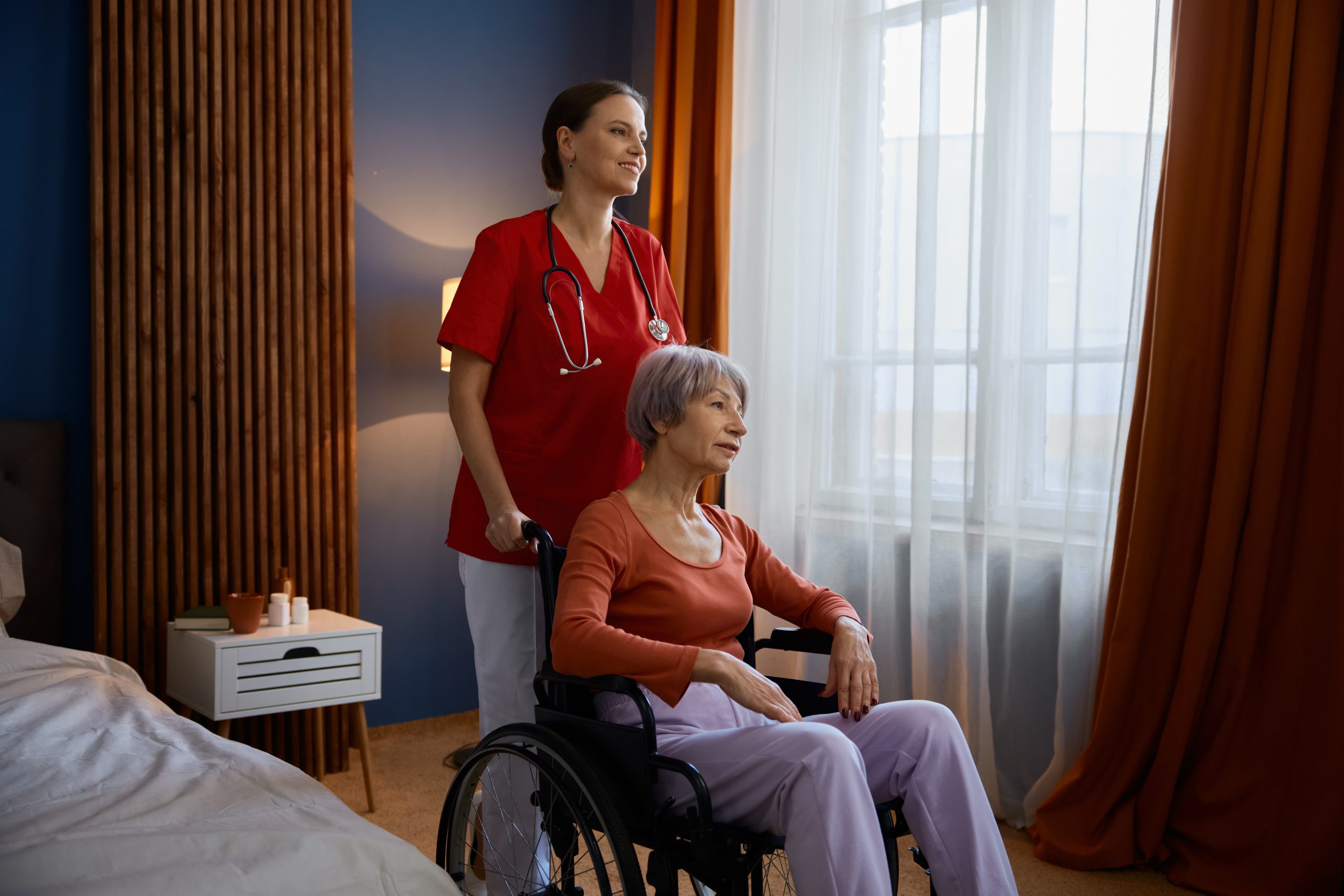 Aged senior woman in wheelchair having professional help at home